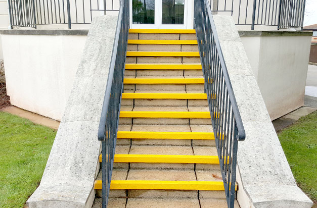 Paving slabs step entrance with anti-slip stair nosing.